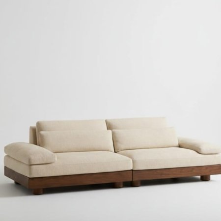 Still sofa with low-profile design, solid wood base, and soft upholstered cushions in a minimalist interior style